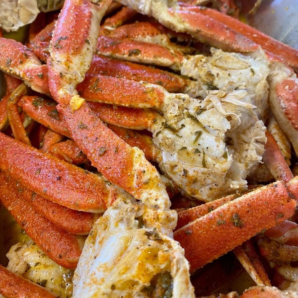 Close-up of LandShark Seafood & Catfish's seasoned crab legs with visible meat and shells.
