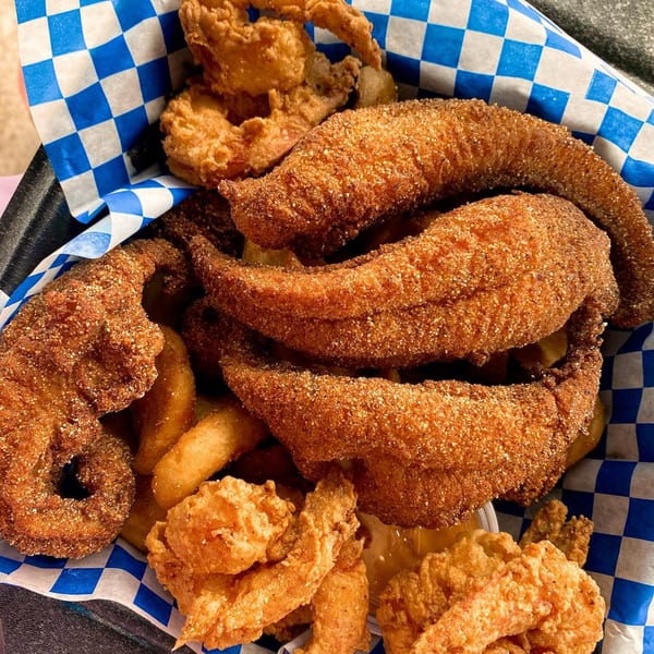 A basket of LandShark Seafood & Catfish fried catfish, shrimp, and onion rings.